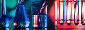 Beakers and test tubes lit in moody blue-green and reddish background
