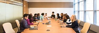 Women seated around a boardroom table - A Call For Progress on DEI